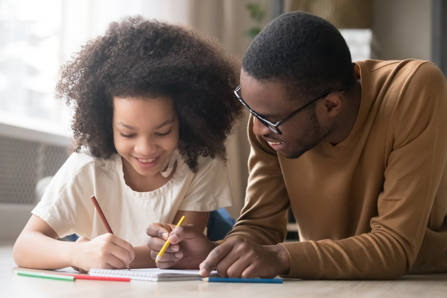 A Young father helping his daughter with homework